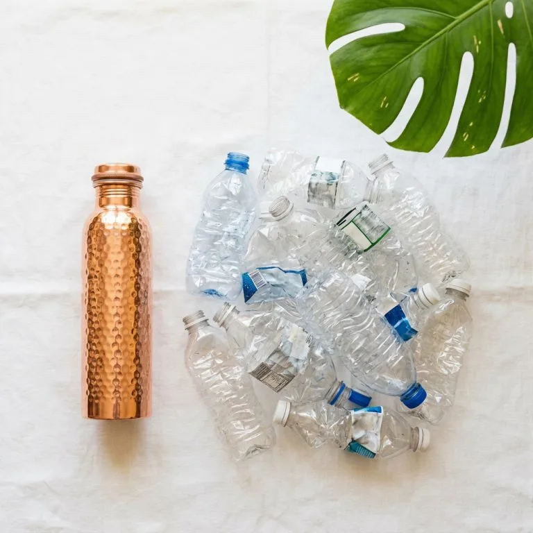 Pure copper water bottle next to plastic bottles showing value comparison — are copper water bottles worth it